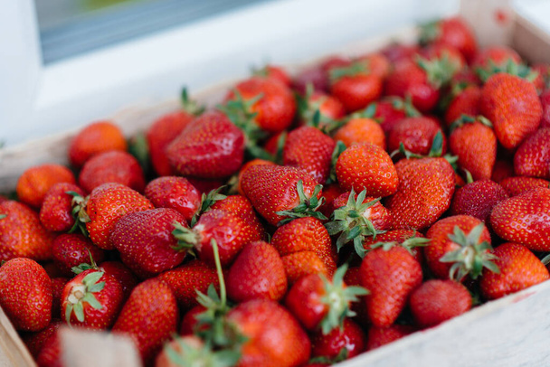 Ripe fresh strawberries close-up in a container for sale. Healthy diet - Fotó, kép