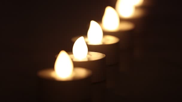 Pięć płonących e-świec w linii z ciemnym tłem - Materiał filmowy, wideo
