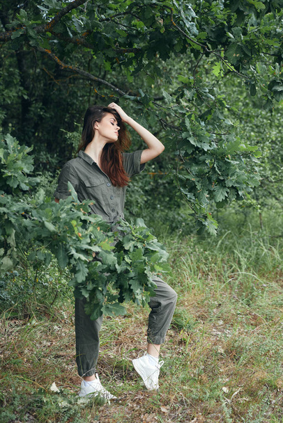 Žena v lese Zavřené oči v zeleném obleku a bílých teniskách  - Fotografie, Obrázek