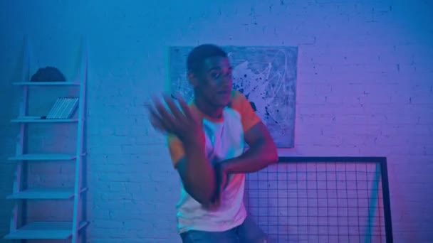 Fröhlicher afrikanisch-amerikanischer Mann tanzt nachts zu Hause  - Filmmaterial, Video
