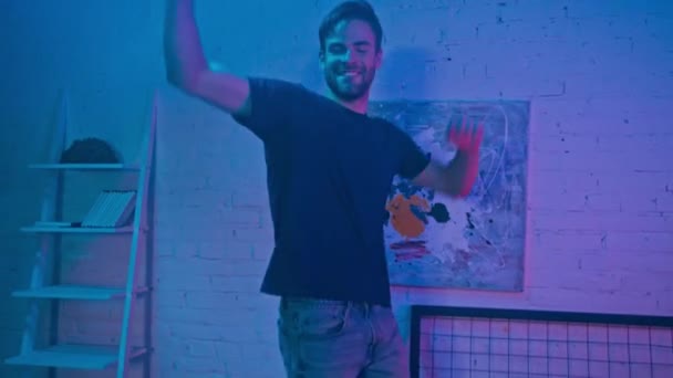 Hombre sonriente bailando en casa durante la noche  - Metraje, vídeo