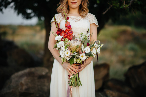 Şaşırtıcı derecede güzel ve şık bir düğün buketi gelini kendine yakın tutar. Çiçekçi - Fotoğraf, Görsel