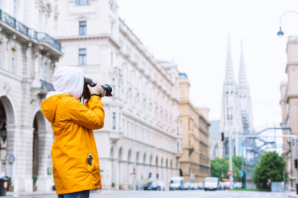 fotograaf toerist neemt foto van de stad straat met votieve kerk op de achtergrond vienna austrië - Foto, afbeelding
