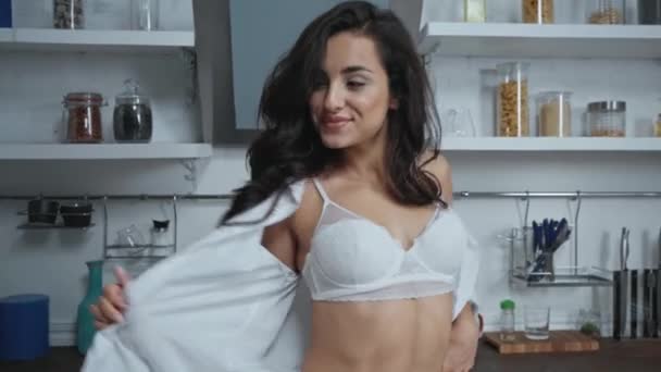 sexy woman in lingerie taking off shirt and throwing it at camera in kitchen - Footage, Video