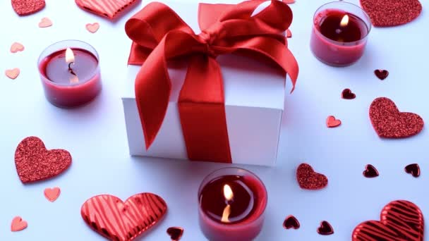Ιστορικό αγάπης: Ημέρα του Αγίου Βαλεντίνου κόκκινες καρδιές, ρομαντικό κουτί δώρου, κερί σε λευκό τραπέζι. Πρότυπο ρομαντικών μηνυμάτων - Πλάνα, βίντεο