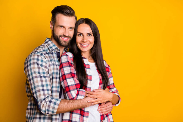 Photo portrait of man hugging woman from behind isolated on vivid yellow colored background with blank space - Zdjęcie, obraz