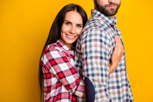 Foto portret van lachend meisje knuffelen echtgenoot van achteren geïsoleerd op levendige geel gekleurde achtergrond - Foto, afbeelding