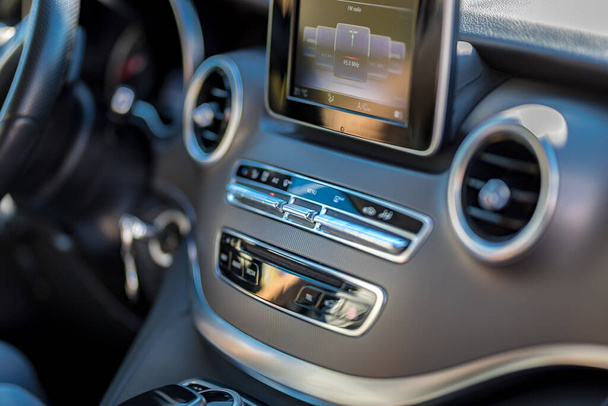 Black leather trim of luxury sports sedan. Dashboard console with multimedia player, gearbox, steering wheel. Selective focus - Photo, image