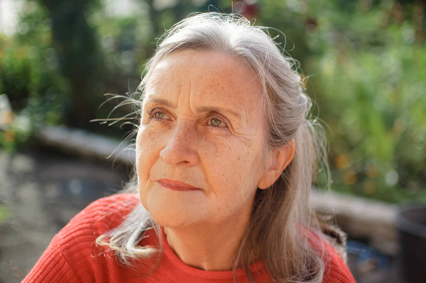 Porträt einer reifen Frau mit grauen Haaren, die an sonnigen Tagen Zeit im Freien verbringt, glücklichen Ruhestand - Foto, Bild