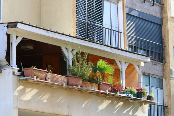 Het balkon is een architectonisch detail van de woningbouw in Israël. Een platform met leuningen die uitsteken op de bovenste verdiepingen van het gebouw.  - Foto, afbeelding