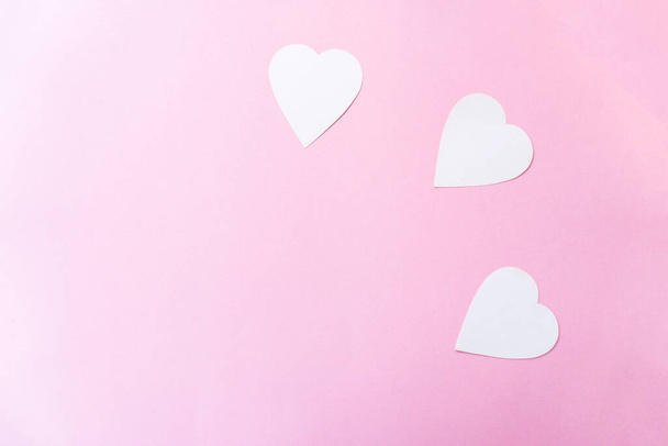 Вид сверху белых бумажных сердец на розовом фоне. Valentine 's D - Фото, изображение