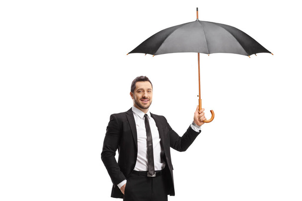 Man in suit and tie holding an umbrella isolated on white background - 写真・画像