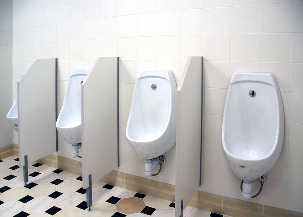 Общественный мужской туалет с белыми туалетами - Фото, изображение
