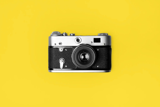 Retro camera isolated on bright yellow background . Pop art concept. Flat lay in minimal style - Fotografie, Obrázek