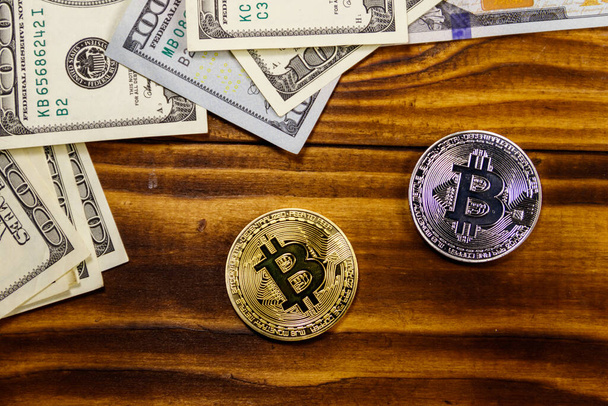 Bitcoins de ouro e prata e notas de cem dólares na mesa de madeira - Foto, Imagem