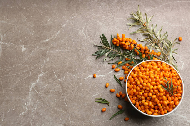 Ripe sea buckthorn berries on marble table, flat lay. Space for text - Foto, Bild