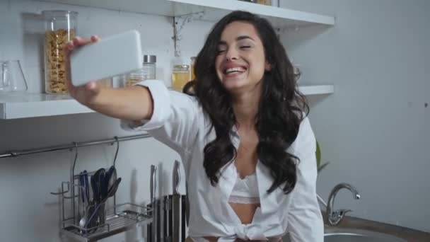 ενθουσιασμένοι, σέξι γυναίκα κουνώντας το χέρι και φυσώντας φιλί αέρα κατά τη διάρκεια της κλήσης βίντεο - Πλάνα, βίντεο