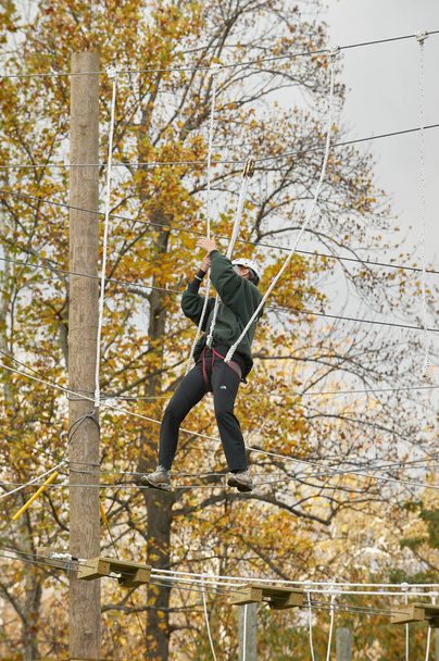High ropes/challenge course.  Participant crossing guide wires - Photo, Image