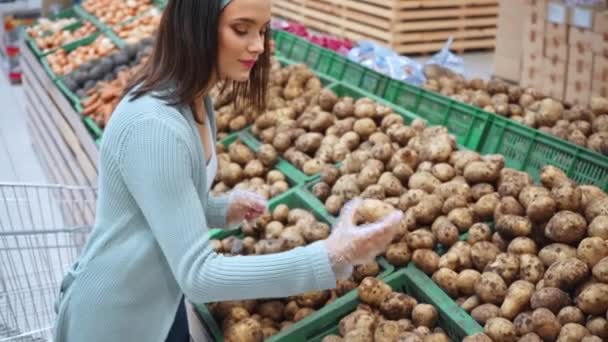 mladý zákazník vybírá brambory v supermarketu  - Záběry, video
