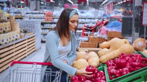happy woman smelling bell pepper in supermarket  - Footage, Video