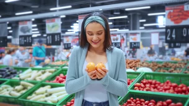 mujer alegre malabares con tomates amarillos en el supermercado  - Imágenes, Vídeo