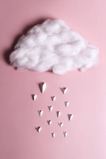 Creative flat lay of heart shape objects falling from the cloud on pastel background. Love concept - Foto, Imagem