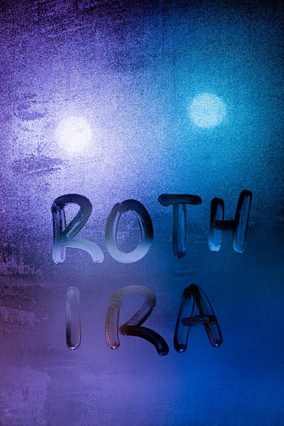 the words roth ira handwritten on night wet window glass surface - Photo, Image