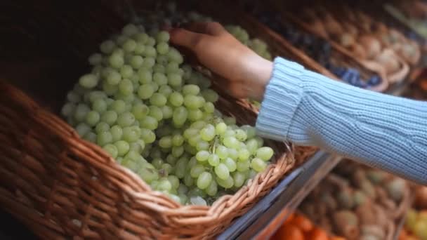 przycięty widok kobiety biorącej winogrona w supermarkecie  - Materiał filmowy, wideo