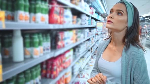 jovem mulher escolher produtos de diário no supermercado  - Filmagem, Vídeo