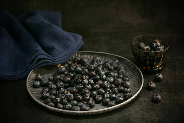 Raw blueberries in a tray on a dark background - Zdjęcie, obraz