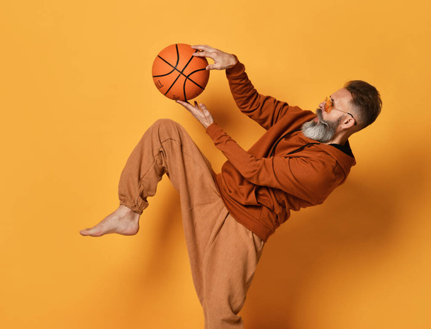 Barefoot bearded man in sportswear caught basket ball - Фото, зображення