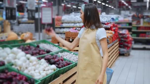 veselý merchandiser drží cibuli a chodí po supermarketu  - Záběry, video