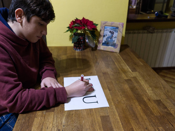 Кавказький хлопчик присвячує малюнок словами "Я люблю У" улюбленій дівчині - Фото, зображення