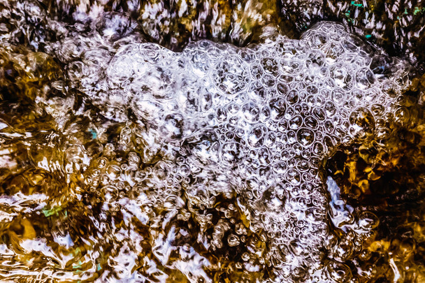 Пузырьки воды в потоке чистой кристаллической воды перед ее загрязнением. - Фото, изображение