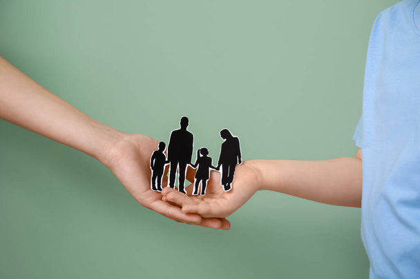 Руки семьи с человеческими фигурами на цветном фоне - Фото, изображение