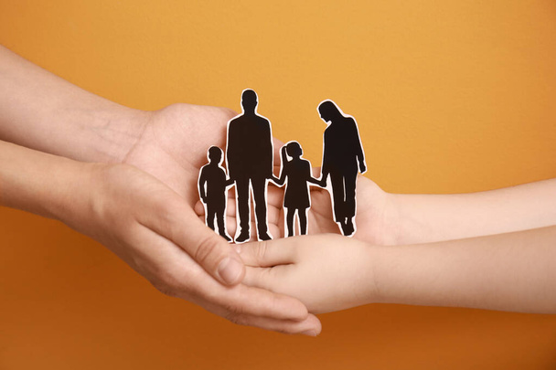 Hands of family with human figures on color background - Photo, Image