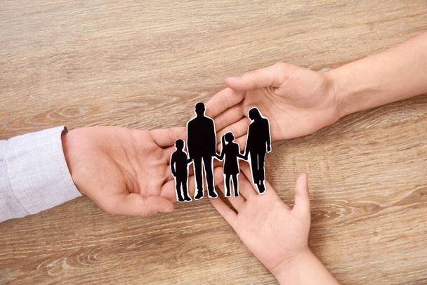 Mains de famille avec des figures humaines sur fond en bois - Photo, image