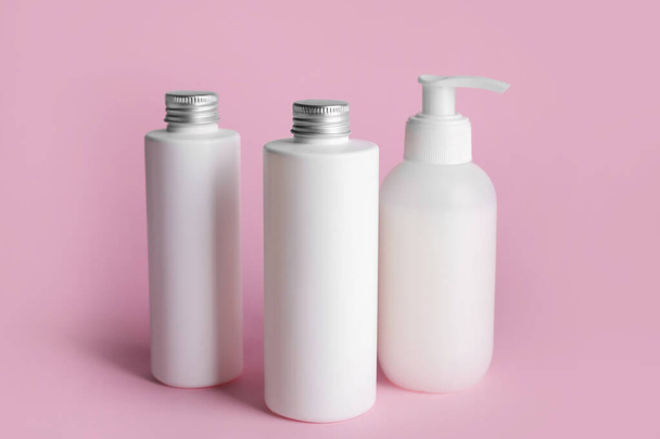 Different bottles of cosmetic products on color background - Foto, imagen