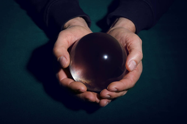 Cajero de la fortuna con bola de cristal sobre fondo oscuro - Foto, Imagen