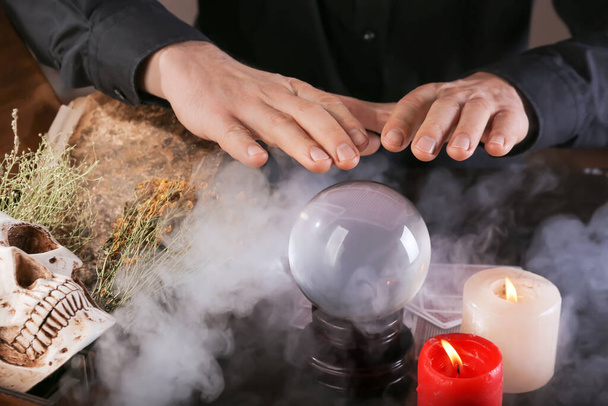 Fortune teller with crystal ball reading future at table - Foto, imagen