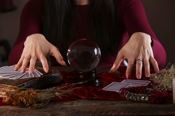 Wróżka z kryształową kulą czytająca przyszłość przy stole - Zdjęcie, obraz