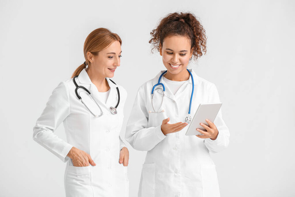 Retrato de doctores femeninos con tableta sobre fondo claro - Foto, Imagen