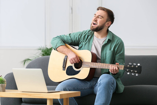 Młody człowiek bierze lekcje muzyki online w domu - Zdjęcie, obraz