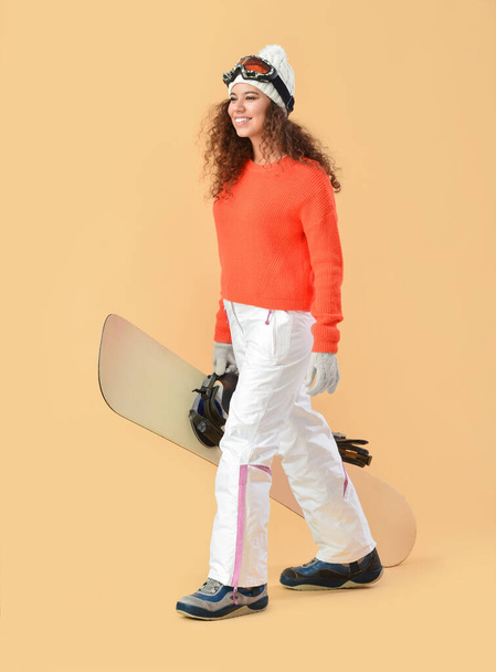 Female snowboarder on color background - Фото, изображение