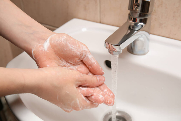 Молодая женщина моет руки в ванной, крупным планом - Фото, изображение