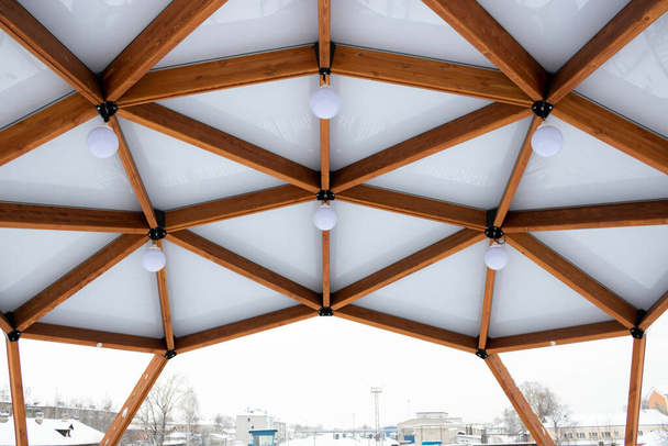 Kışın açık havada, kahverengi ahşap bir balkonda fenerlerin olduğu cam tavan.. - Fotoğraf, Görsel