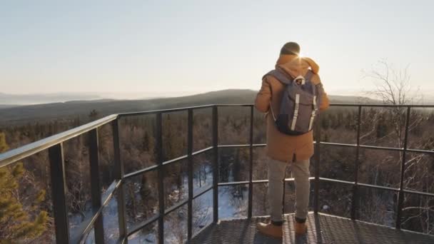 Taustakuva hidastettuna täynnä mies turisti reppu nauttia talvi maisema ylhäältä päivänvalossa - Materiaali, video