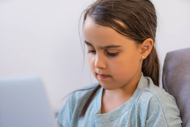 Mała dziewczynka korzystająca z cyfrowego laptopa E-learning Concept. małe dziewczynki korzystające z laptopa, studiujące przez system e-learningowy online. - Zdjęcie, obraz