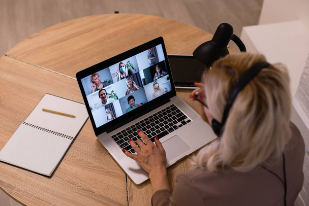 Nő birtoklás video chat kollégák a laptop az irodában, közelkép - Fotó, kép