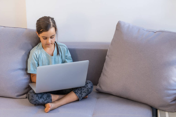 Mała dziewczynka korzystająca z cyfrowego laptopa E-learning Concept. małe dziewczynki korzystające z laptopa, studiujące przez system e-learningowy online. - Zdjęcie, obraz